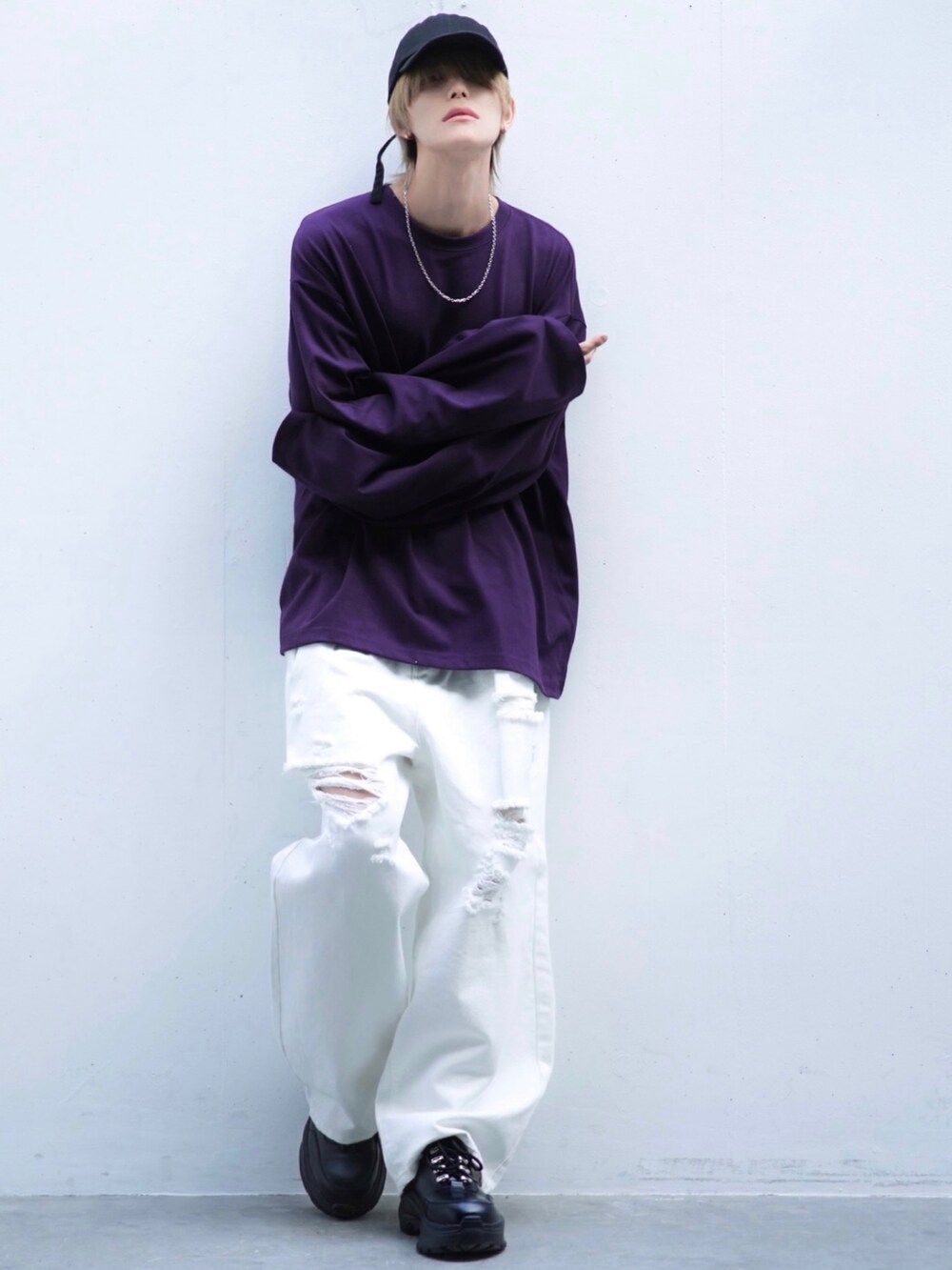 ブラック系のスニーカー、パープル系のTシャツ/カットソー、ホワイト系のデニムパンツを着用したメンズの春コーディネートの2枚目の写真