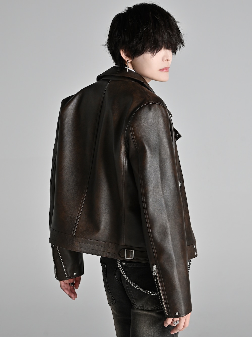 ブラウン系のブルゾン、ブラック系のローファー、ブラック系のデニムパンツを着用したメンズの冬コーディネートの5枚目の写真