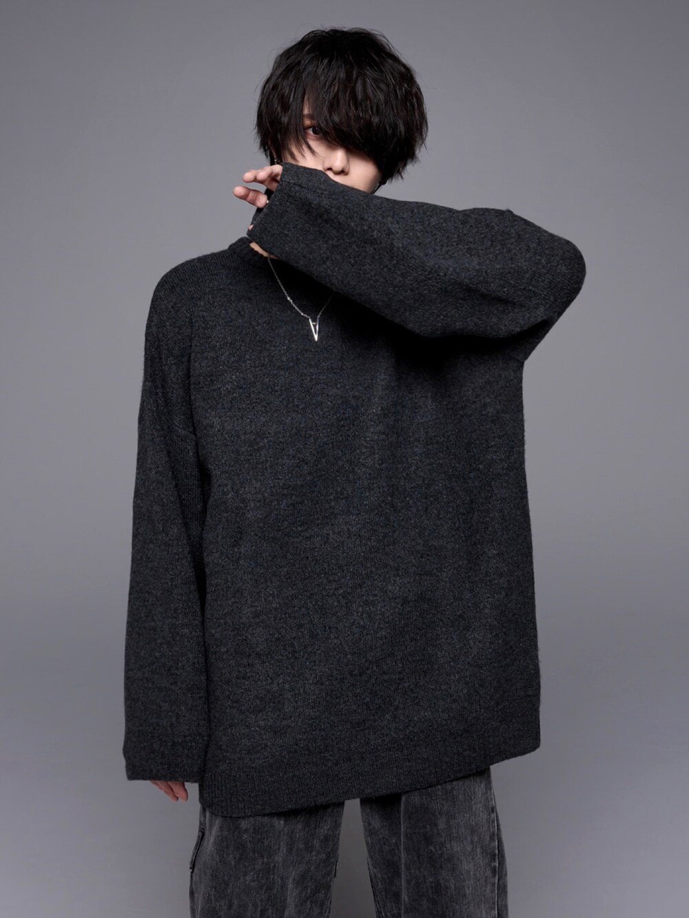 ブラック系のデニムパンツ、ブラック系のローファー、ブラック系のニット/セーターを着用したメンズの秋コーディネートの4枚目の写真