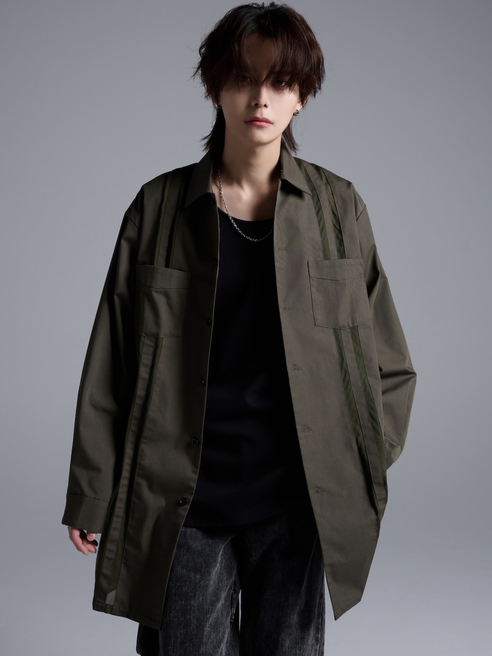 ブラック系のデニムパンツ、ブラック系のブーツ、グリーン系のシャツ/ブラウスを着用したメンズの春コーディネートの3枚目の写真