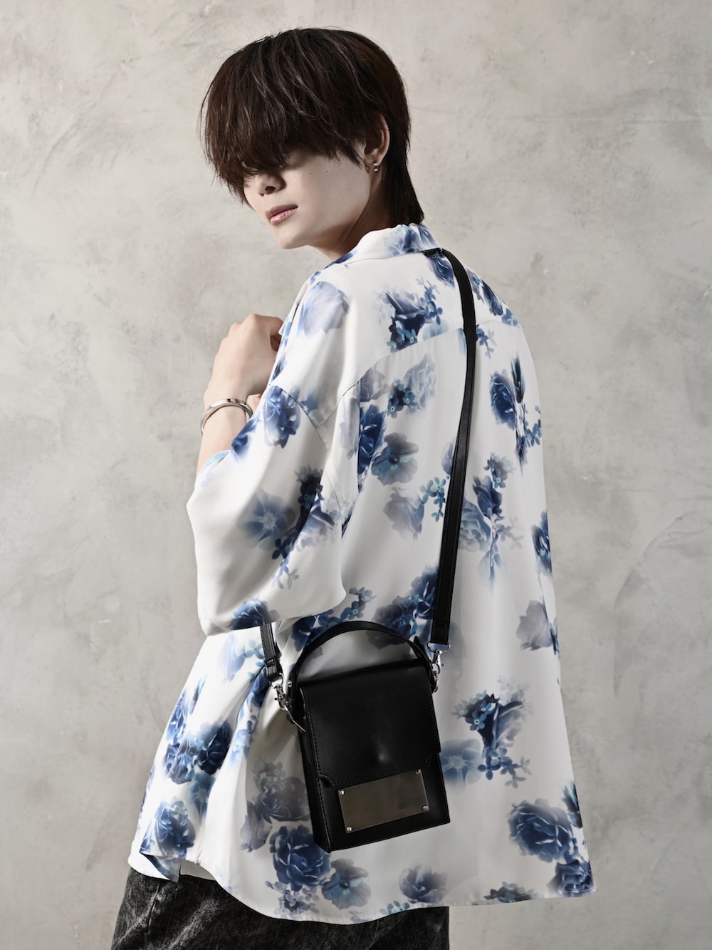 ホワイト系のタンクトップ、ブラック系のデニムパンツ、ブラック系のショルダーバッグを着用したメンズの春コーディネートの5枚目の写真