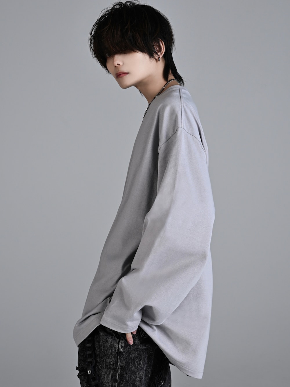 ブラック系のデニムパンツ、ブラック系のスニーカー、ブラック系のショルダーバッグを着用したメンズの秋コーディネートの3枚目の写真