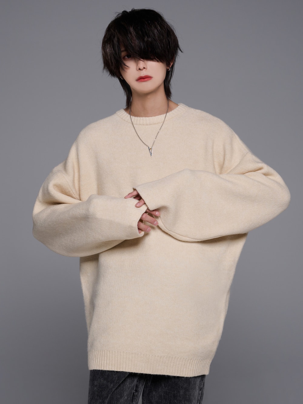 ブラック系のデニムパンツ、ブラック系のブーツ、ホワイト系のニット/セーターを着用したメンズの秋コーディネートの4枚目の写真