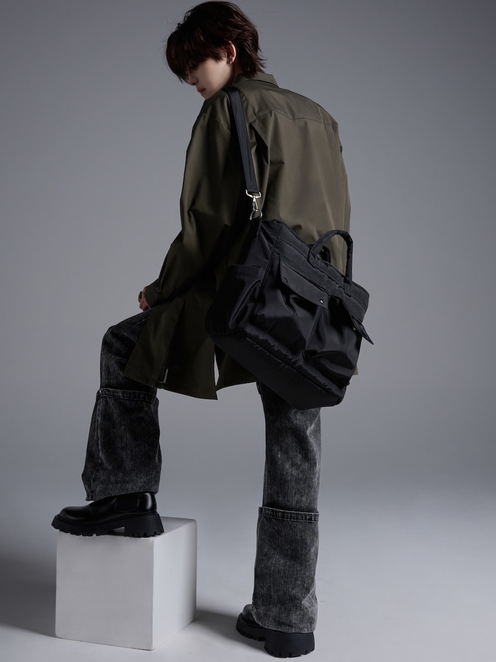 ブラック系のデニムパンツ、ブラック系のブーツ、グリーン系のシャツ/ブラウスを着用したメンズの春コーディネートの2枚目の写真