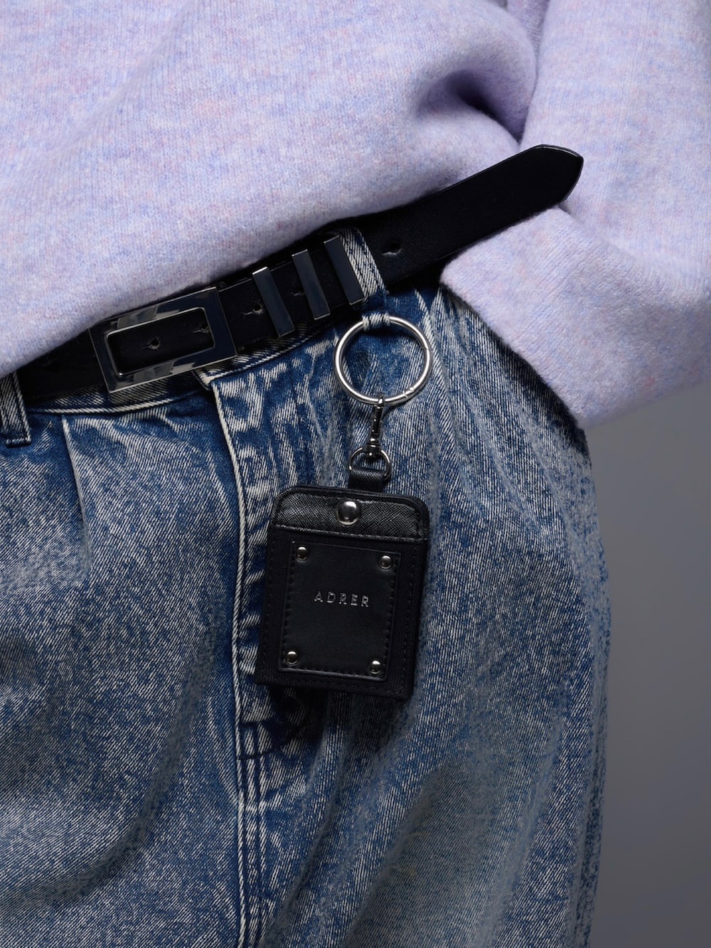 ブルー系のデニムパンツ、ブラック系のスニーカー、パープル系のニット/セーターを着用したメンズの秋コーディネートの5枚目の写真