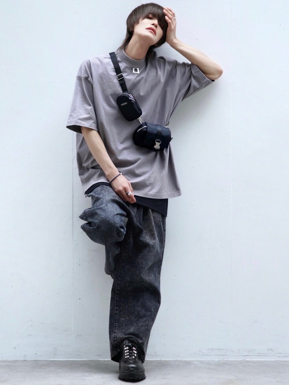 ブラック系のデニムパンツ、ブラック系のスニーカー、ブラック系のショルダーバッグを着用したメンズの春コーディネートの2枚目の写真