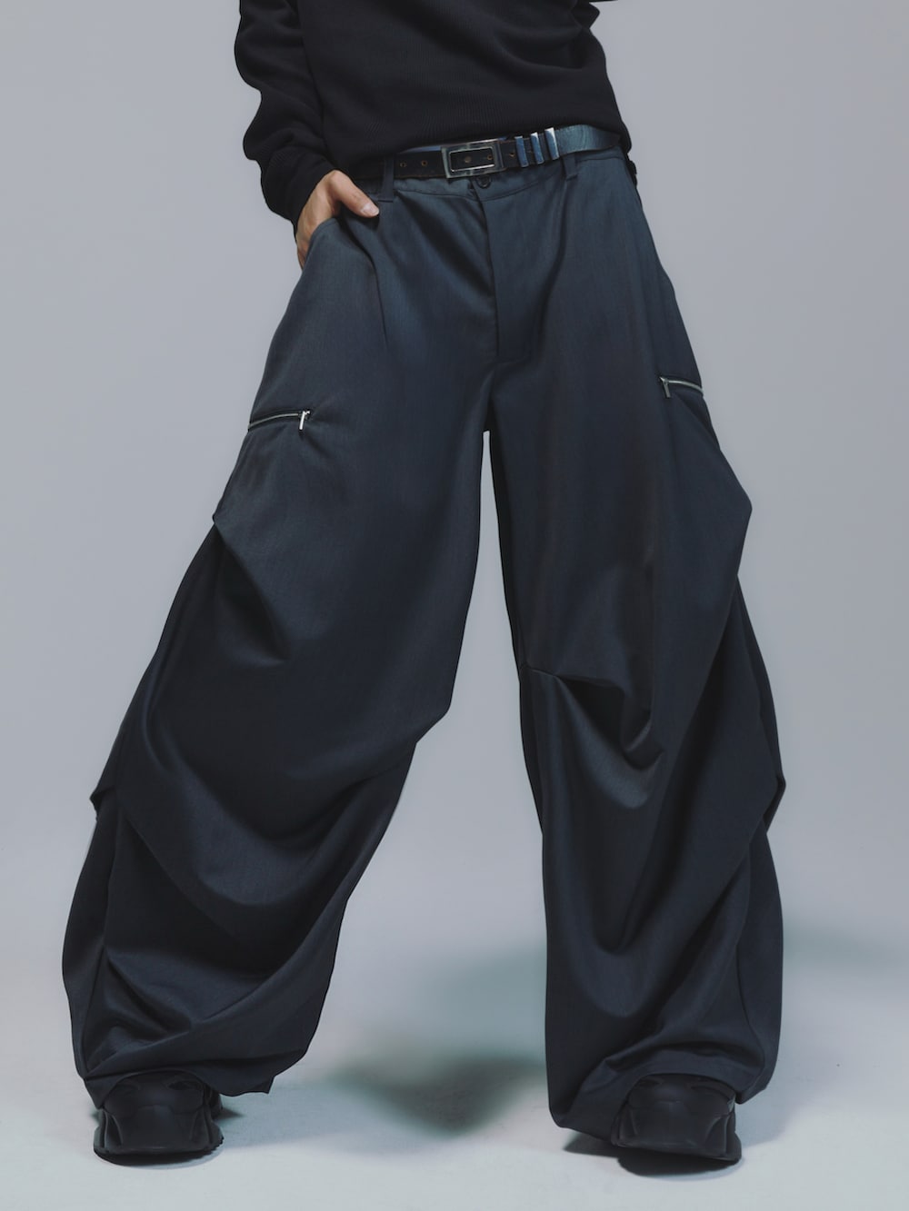 ブラック系のパーカー、レッド系のタンクトップ、ブラック系のスラックスを着用したメンズの秋コーディネートの2枚目の写真