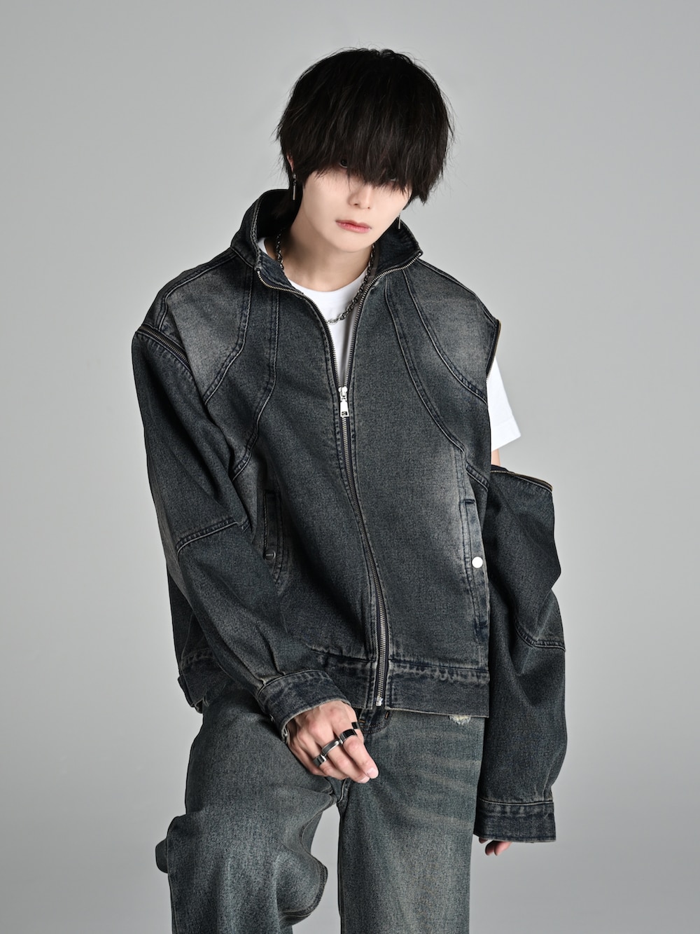 ブラック系のパーカー、ブルー系のデニムジャケット、ブラック系のカーゴパンツを着用したメンズの冬コーディネートの3枚目の写真