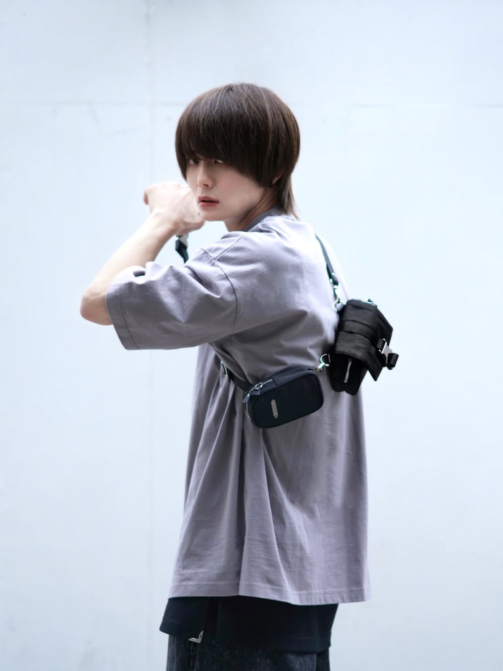 ブラック系のデニムパンツ、ブラック系のスニーカー、ブラック系のショルダーバッグを着用したメンズの春コーディネートの5枚目の写真