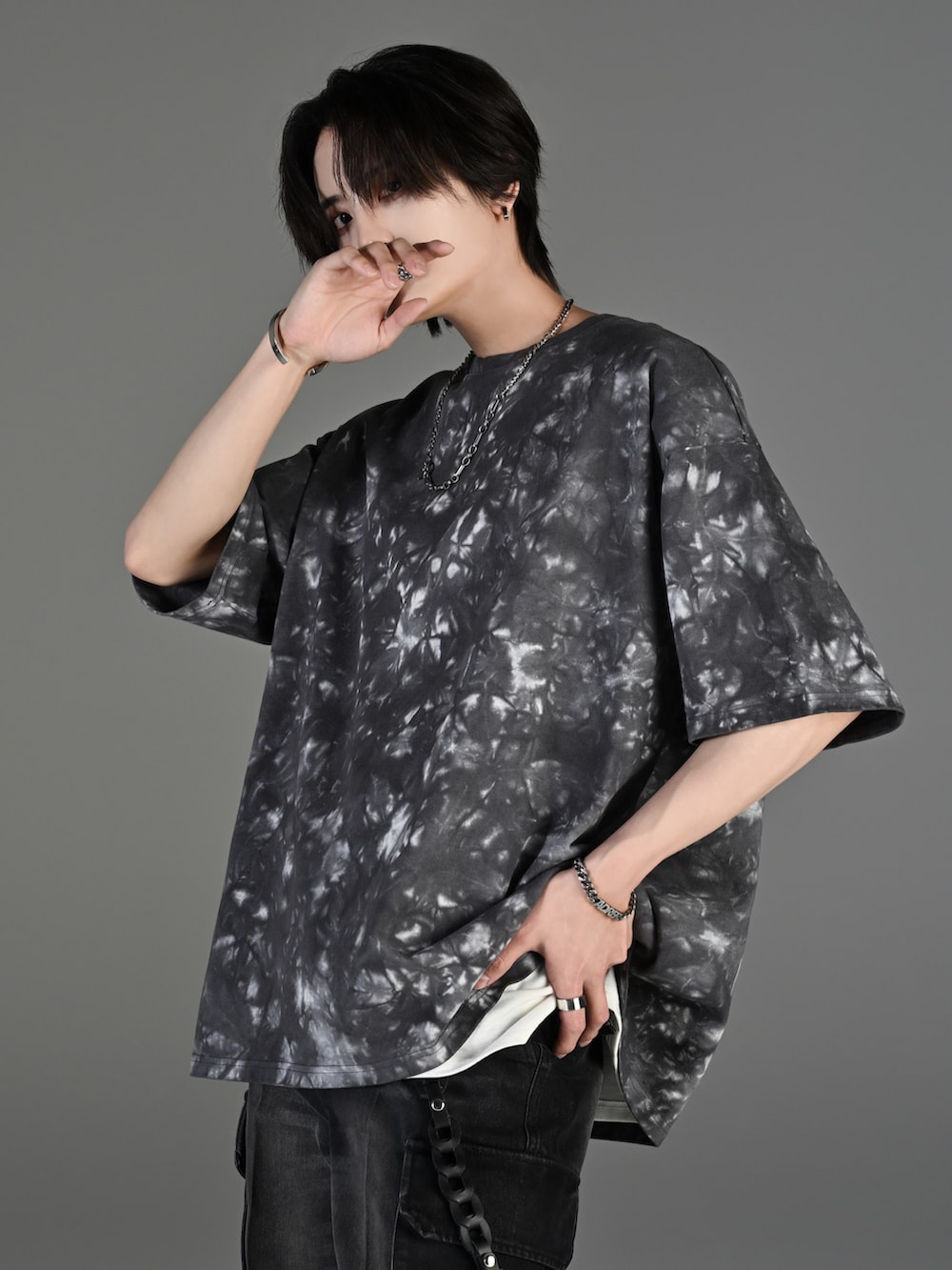 ブラック系のカーゴパンツ、ブラック系のスニーカー、ブラック系のショルダーバッグを着用したメンズの春コーディネートの2枚目の写真