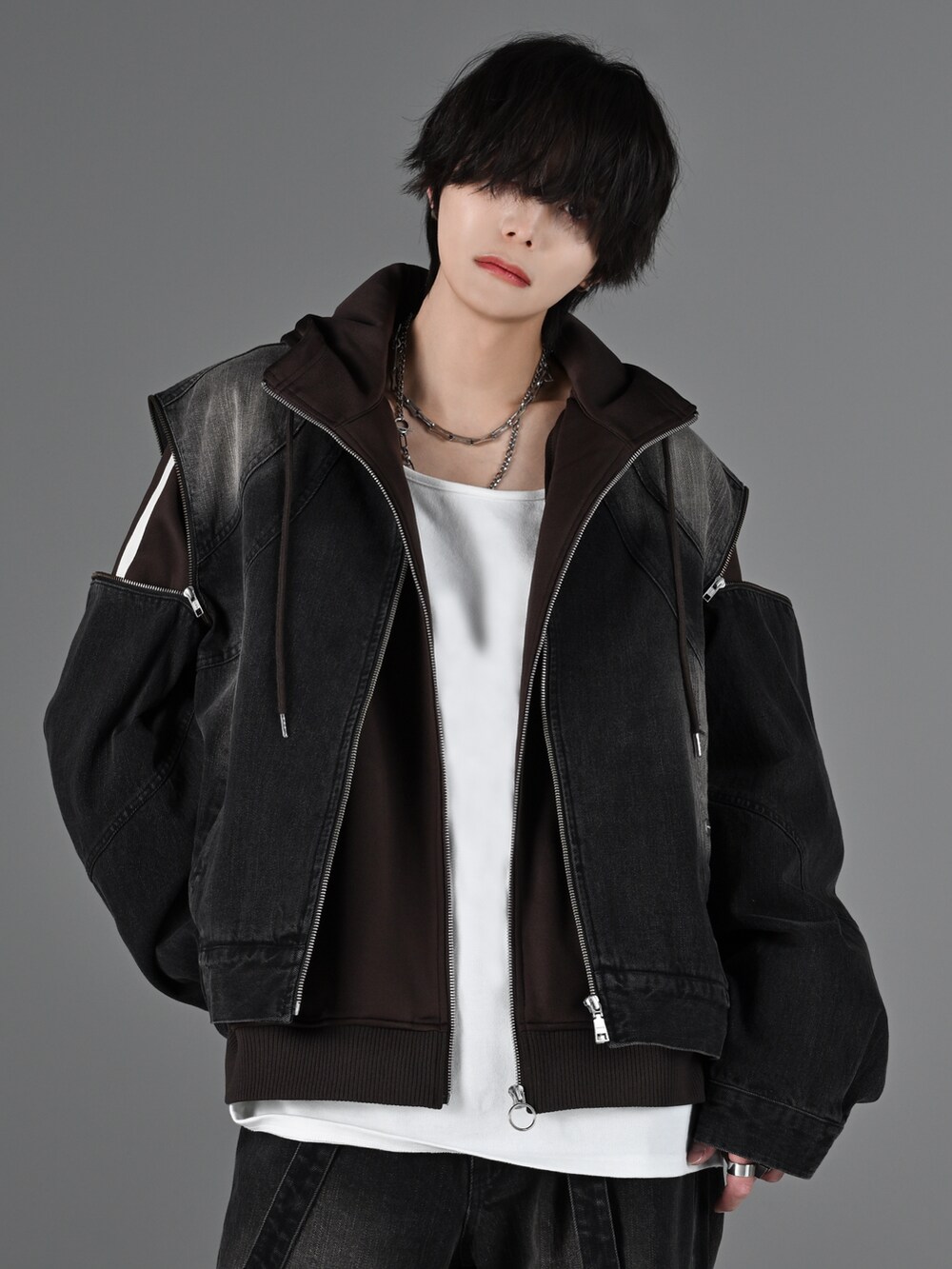 グレー系のタンクトップ、ブラック系のデニムパンツ、ホワイト系のスニーカーを着用したメンズの冬コーディネートの2枚目の写真