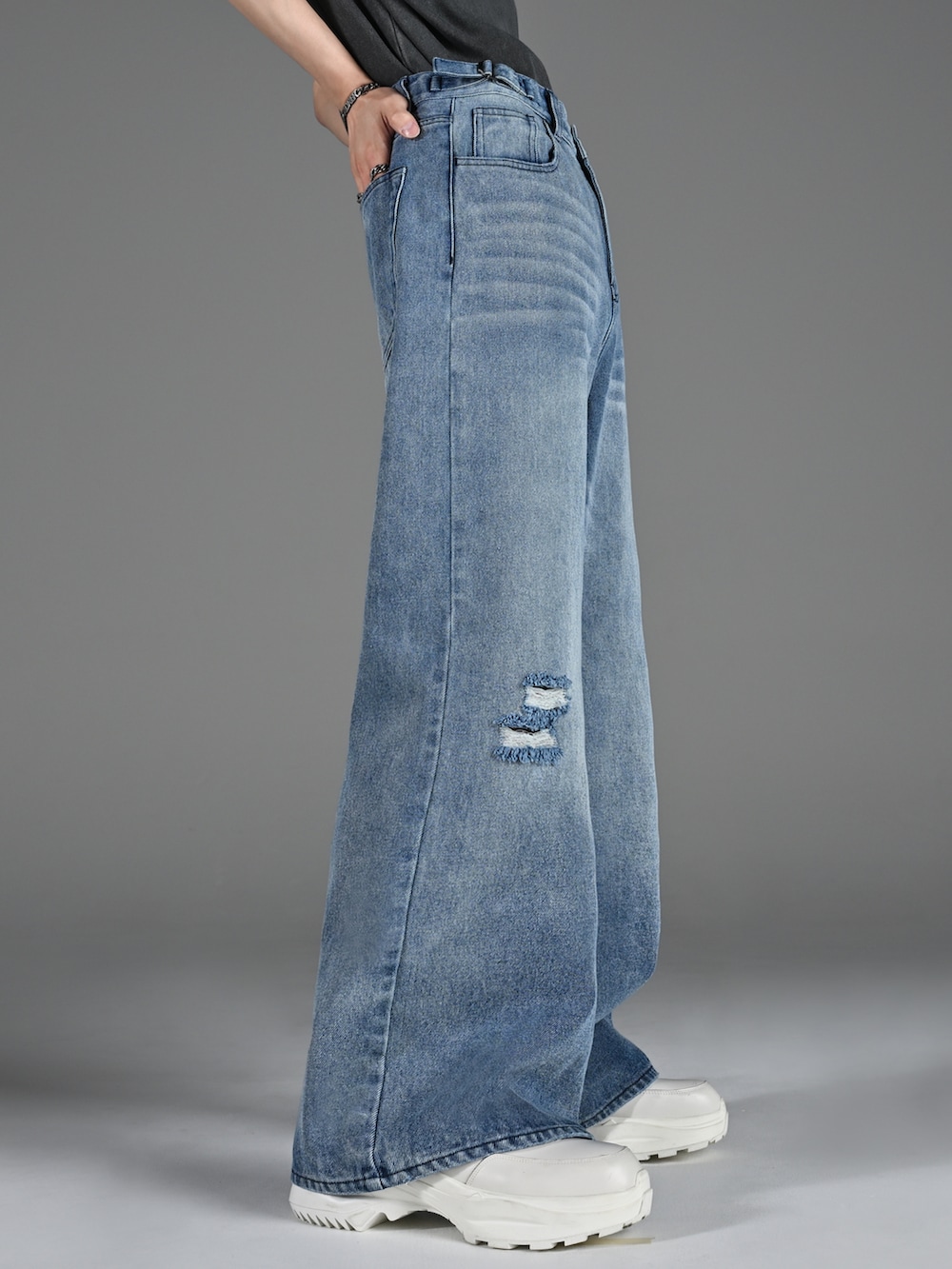 ブラック系のブーツ、グレー系のTシャツ/カットソー、ブルー系のデニムパンツを着用したメンズの春コーディネートの4枚目の写真