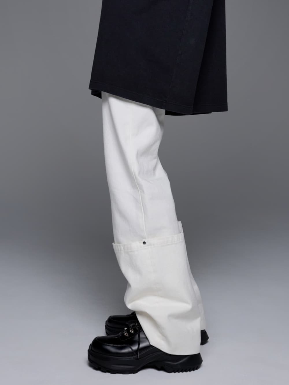 ブラック系のスニーカー、ブラック系のパーカー、ホワイト系のデニムパンツを着用したメンズの夏コーディネートの3枚目の写真