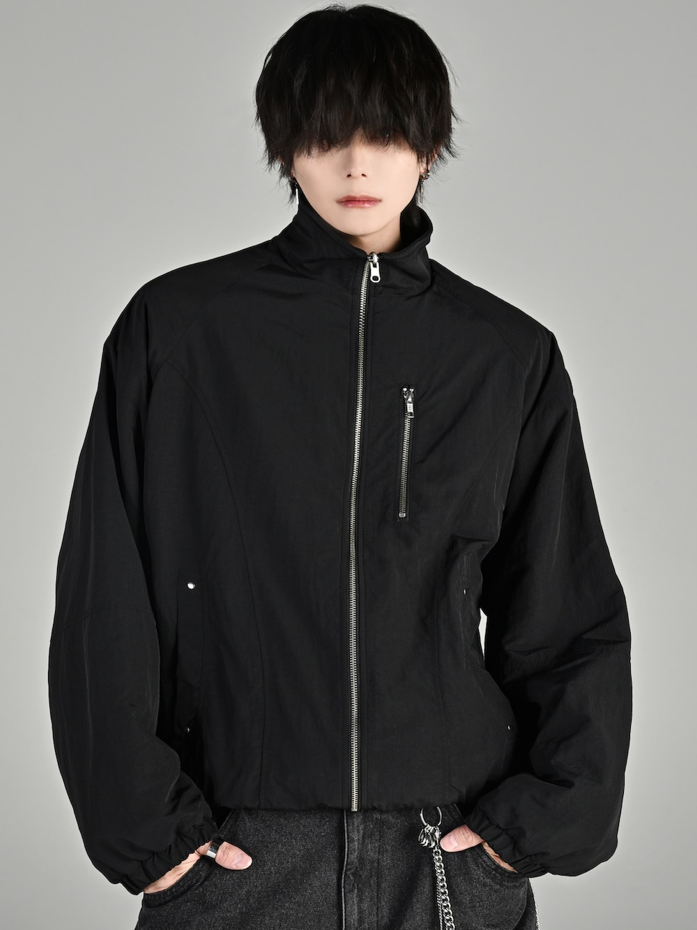 ベージュ系のブーツ、ブラック系のブルゾン、グレー系のスウェットパンツを着用したメンズの秋コーディネートの3枚目の写真