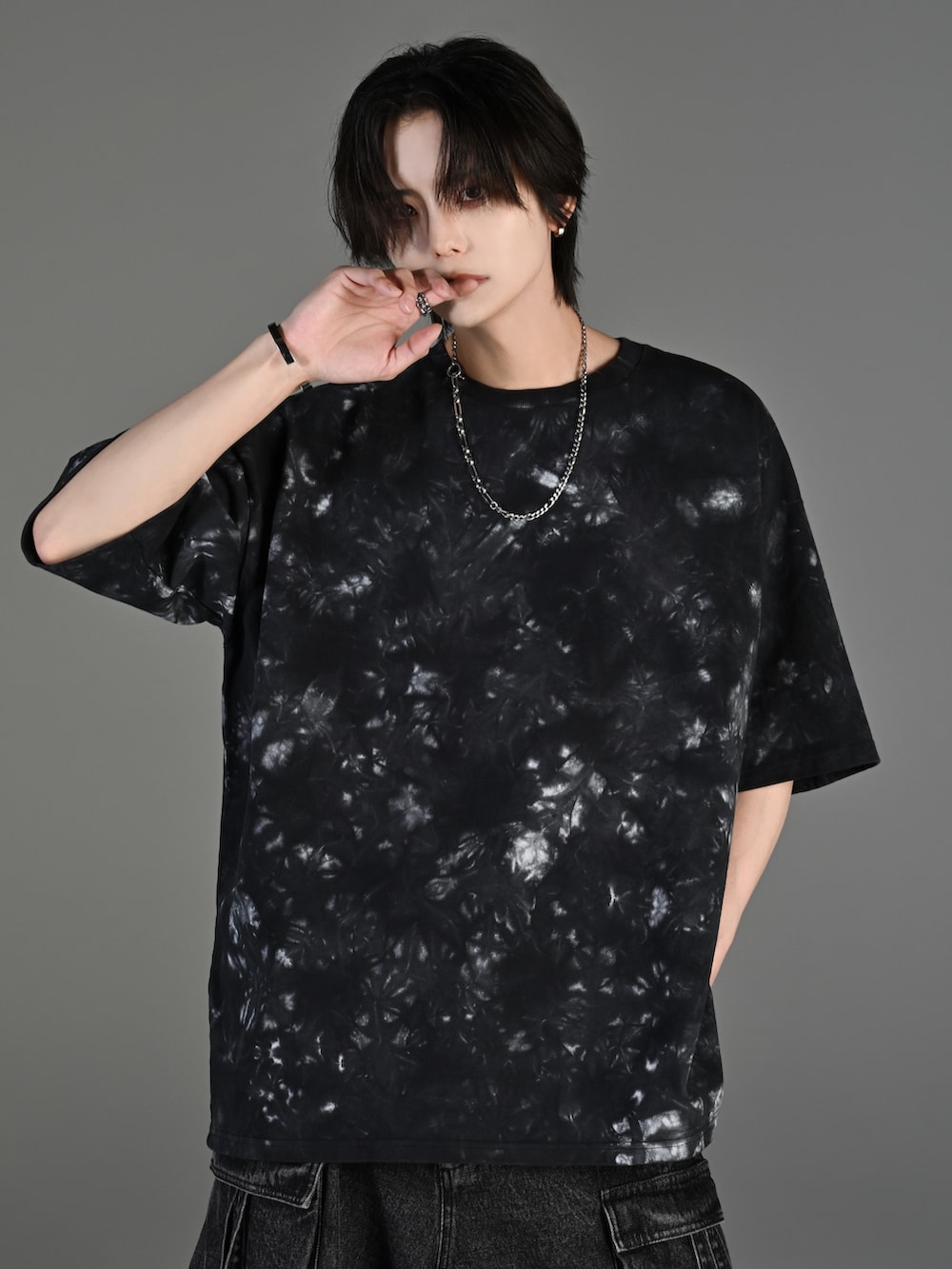 グレー系のタンクトップ、ブラック系のカーゴパンツ、ホワイト系のスニーカーを着用したメンズの春コーディネートの2枚目の写真