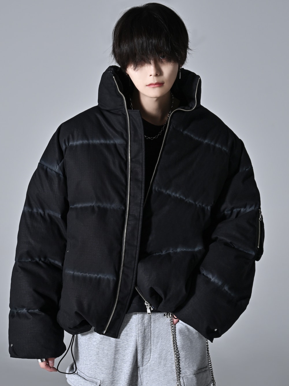 ブラック系のダウンジャケット/コート、ベージュ系のブーツ、グレー系のカーゴパンツを着用したメンズの秋コーディネートの2枚目の写真