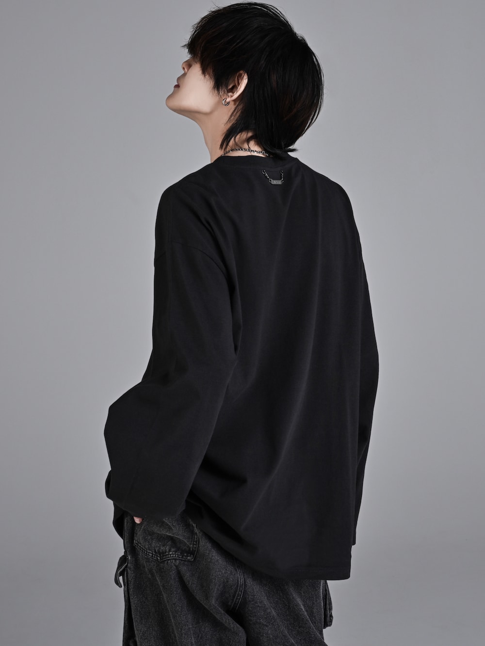 ブラック系のカーゴパンツ、ホワイト系のスニーカー、ブラック系のショルダーバッグを着用したメンズの秋コーディネートの4枚目の写真