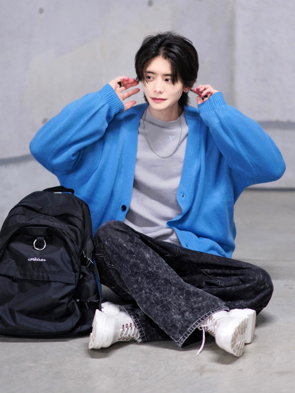 ブラック系のデニムパンツ、ホワイト系のスニーカー、ブラック系のバックパック/リュックを着用したメンズの冬コーディネートの4枚目の写真