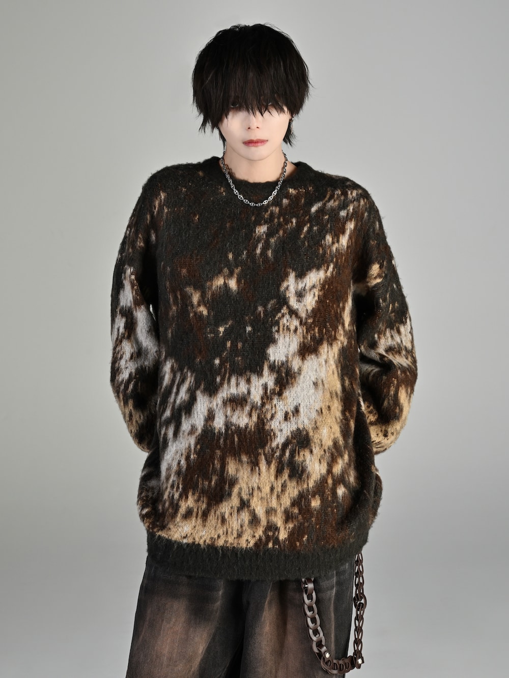 ブラック系のスニーカー、ブラウン系のニット/セーター、ブラック系のデニムパンツを着用したメンズの秋コーディネートの2枚目の写真