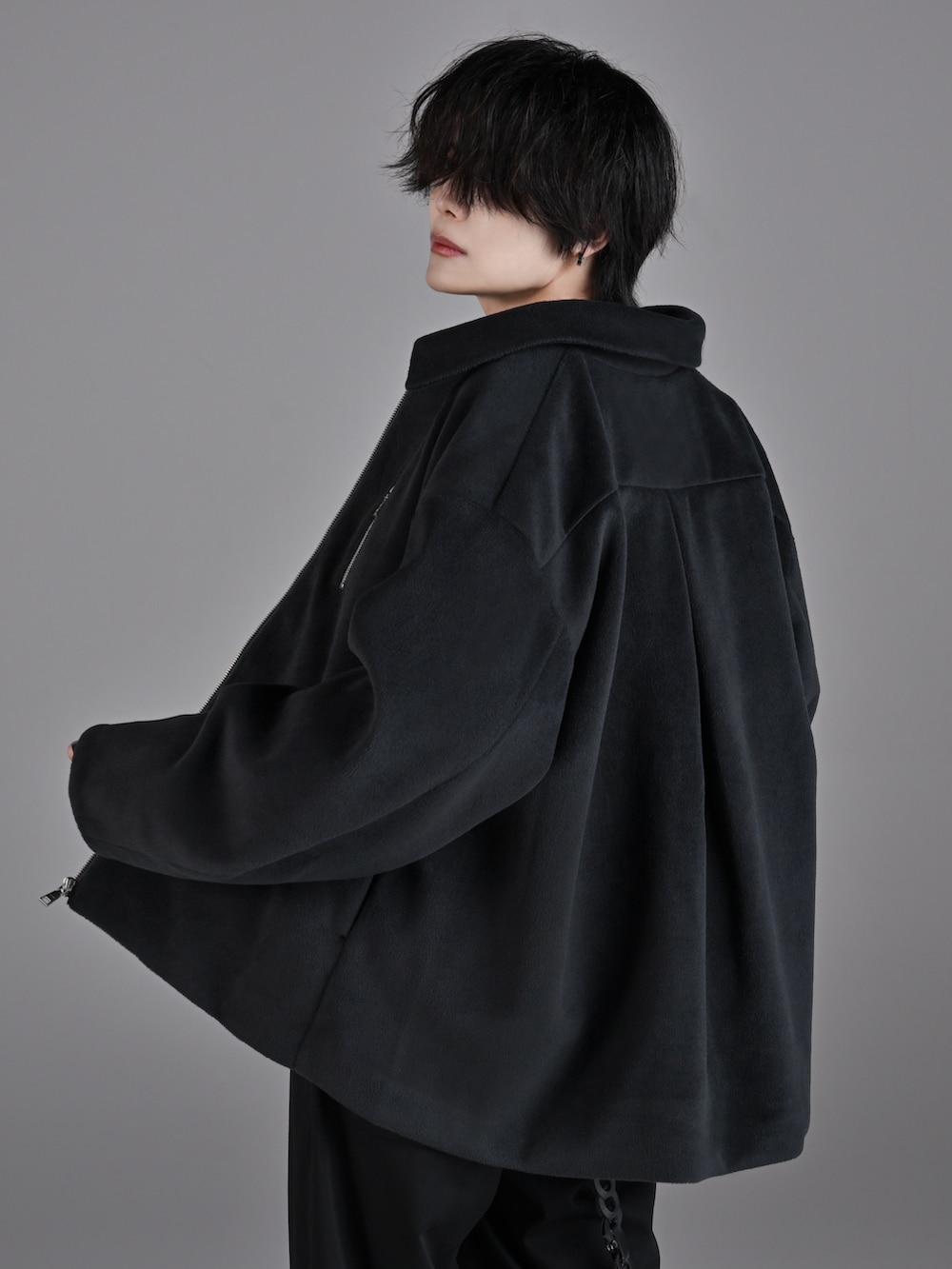 ブラック系のスラックス、ホワイト系のスニーカー、グレー系のブルゾンを着用したメンズの秋コーディネートの5枚目の写真