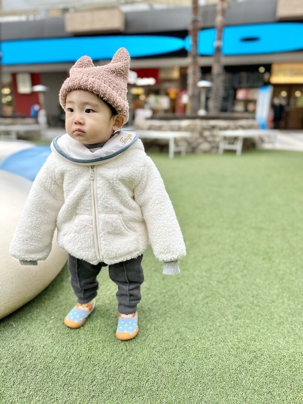 グレー系のカーディガン/ボレロ、イエロー系のシャツ/ブラウス、ホワイト系のソックス/靴下を着用したキッズの冬コーディネートの2枚目の写真