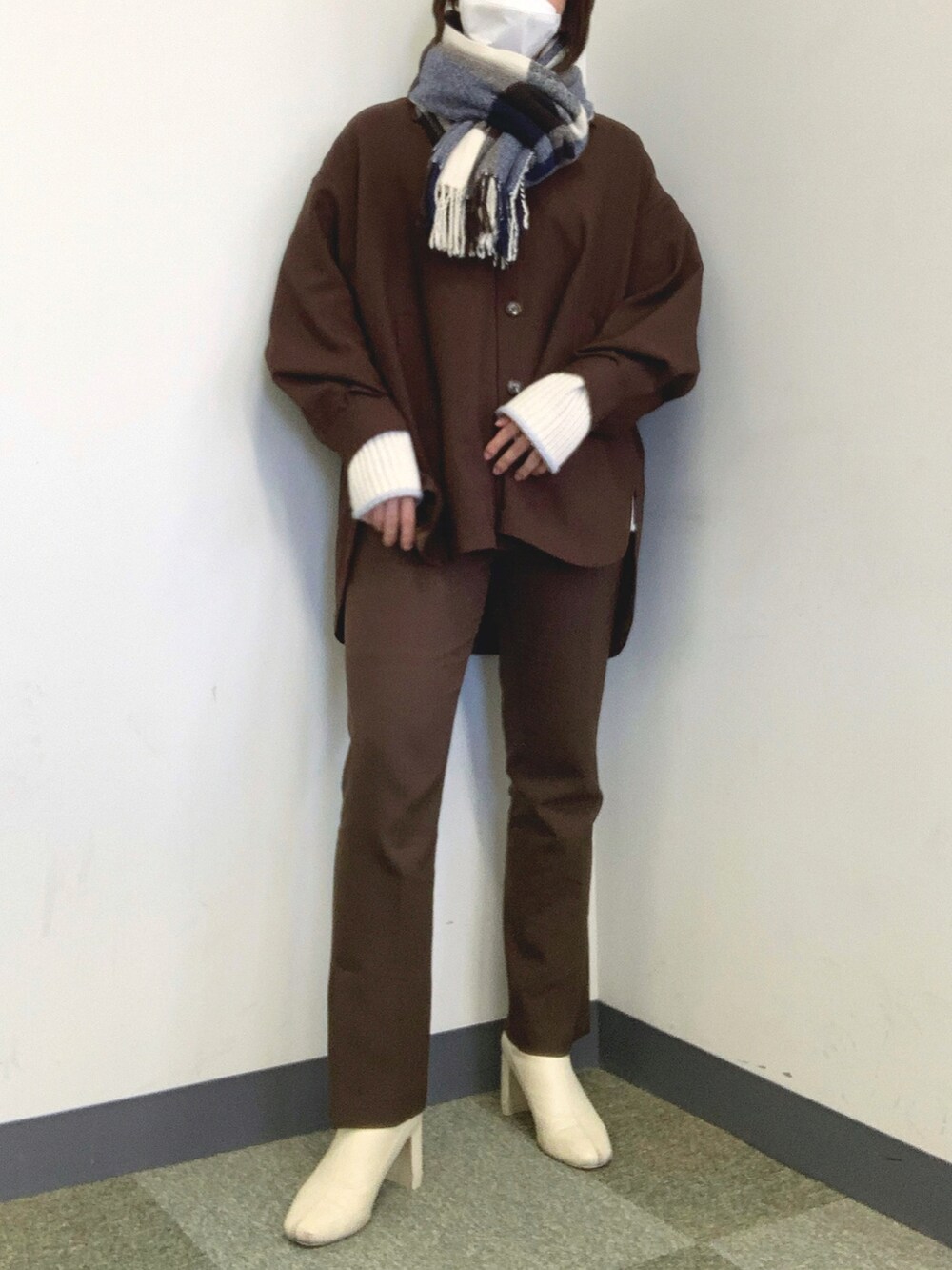 ホワイト系のブーツ、ブラウン系のテーラードジャケット、ホワイト系のニット/セーターを着用したレディースの冬コーディネートの2枚目の写真