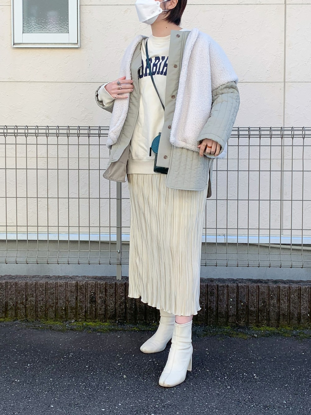 ホワイト系のスカート、ホワイト系のブーツ、ホワイト系のスウェットを着用したレディースの冬コーディネートの2枚目の写真