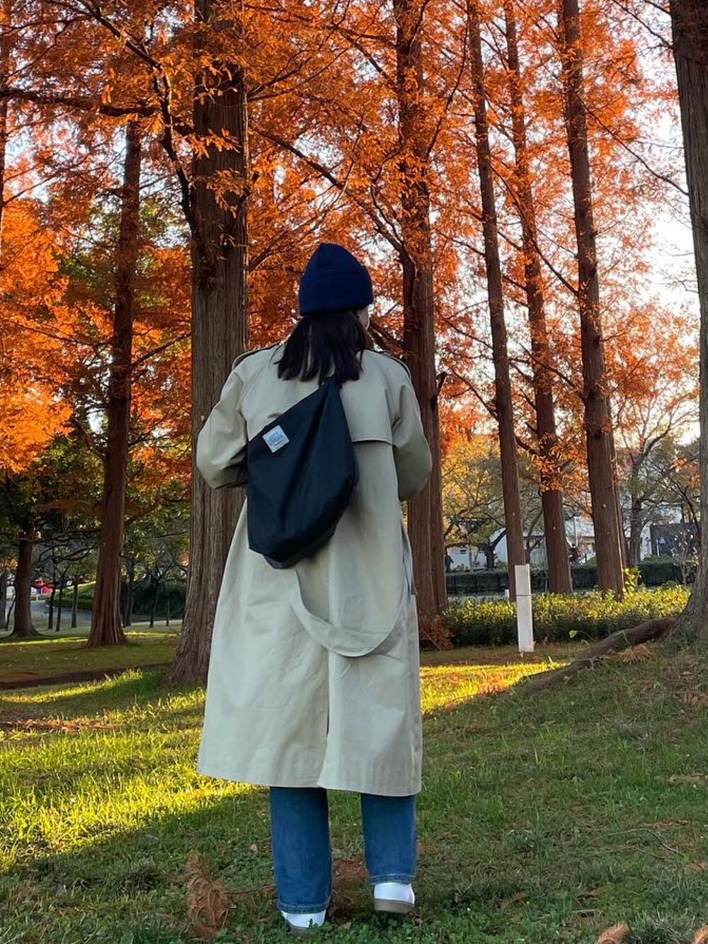 「トレンチコート、ニット帽、秋のコーデ、紅葉、きれいめカジュアル、CANADA GOOSE、公園、スポーツカジュアル、ジャーマントレーナー、GERMAN TRAINER」｜「UNIQLOのウルトラライトダウンコンパクトベスト（ダウンジャケット/コート、ブルー系）」を使った、しゃかりき・リラックスさん（レディース・159cm）の冬コーディネートの2枚目の写真