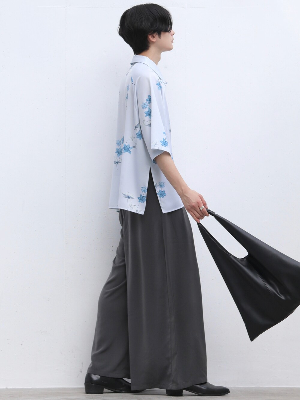 グレー系のスカート、ブラック系のブーツ、ブラック系のトートバッグを着用したメンズの夏コーディネートの2枚目の写真