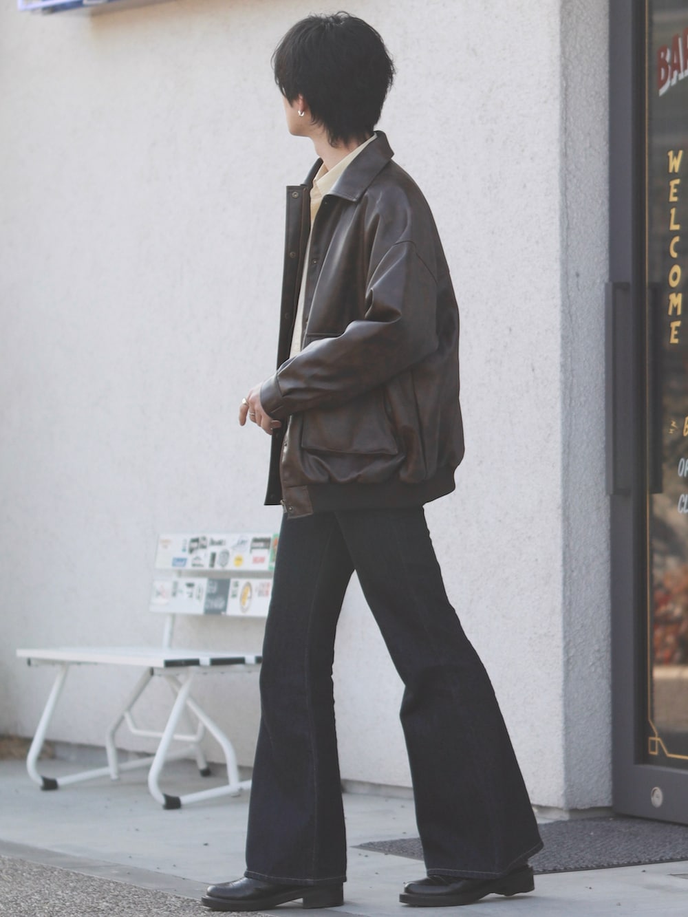 ブラウン系のブルゾン、イエロー系のシャツ/ブラウス、ブルー系のデニムパンツを着用したメンズの春コーディネートの2枚目の写真