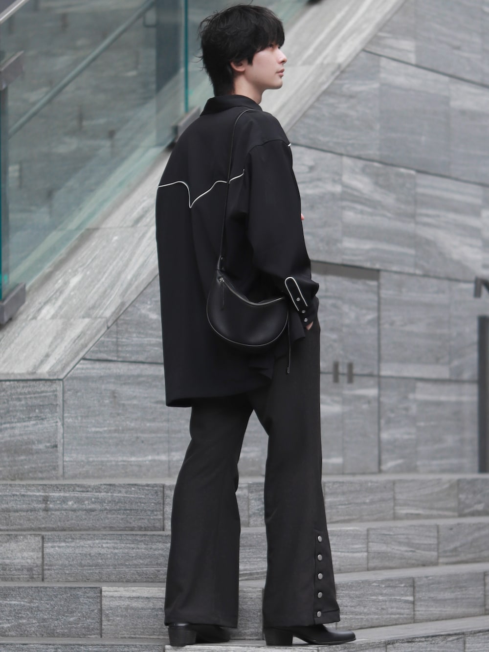 ブラック系のシャツ/ブラウス、ブラック系のショルダーバッグ、シルバー系のネックレスを着用したメンズの春コーディネートの2枚目の写真