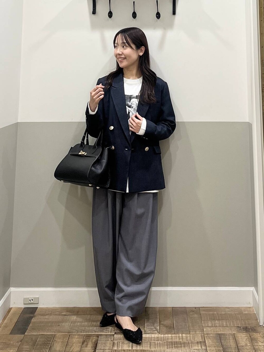 グレー系のスラックス、ブルー系のテーラードジャケット、ホワイト系のTシャツ/カットソーを着用したレディースの冬コーディネートの2枚目の写真