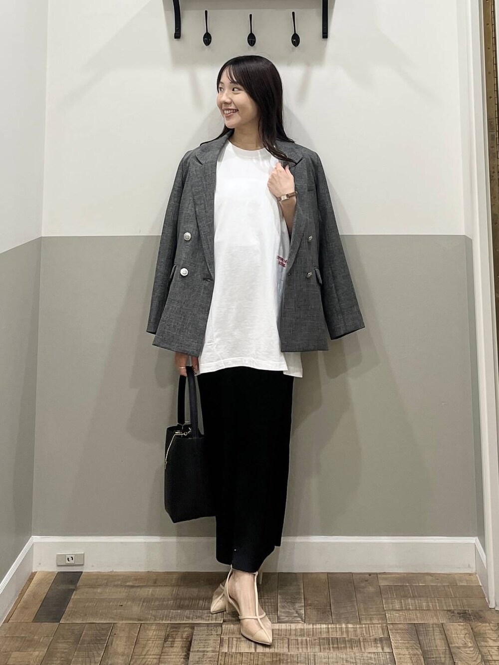 ブラック系のスカート、ブラック系のテーラードジャケット、ブラック系のショルダーバッグを着用したレディースの冬コーディネートの4枚目の写真