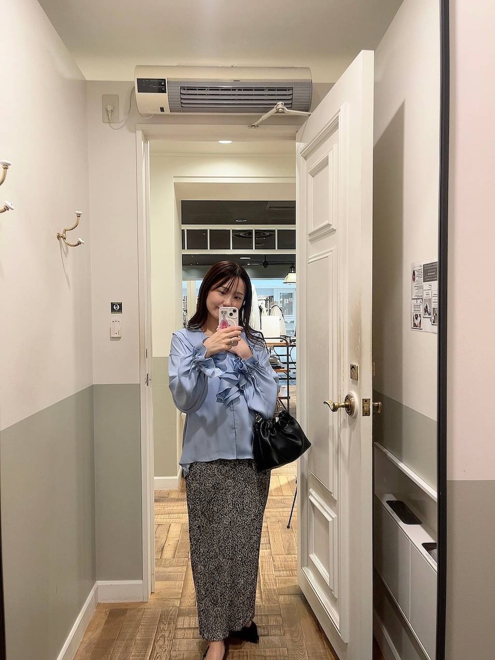 ベージュ系のスカート、ブラック系のショルダーバッグ、ホワイト系のキャミソールを着用したレディースの冬コーディネートの4枚目の写真