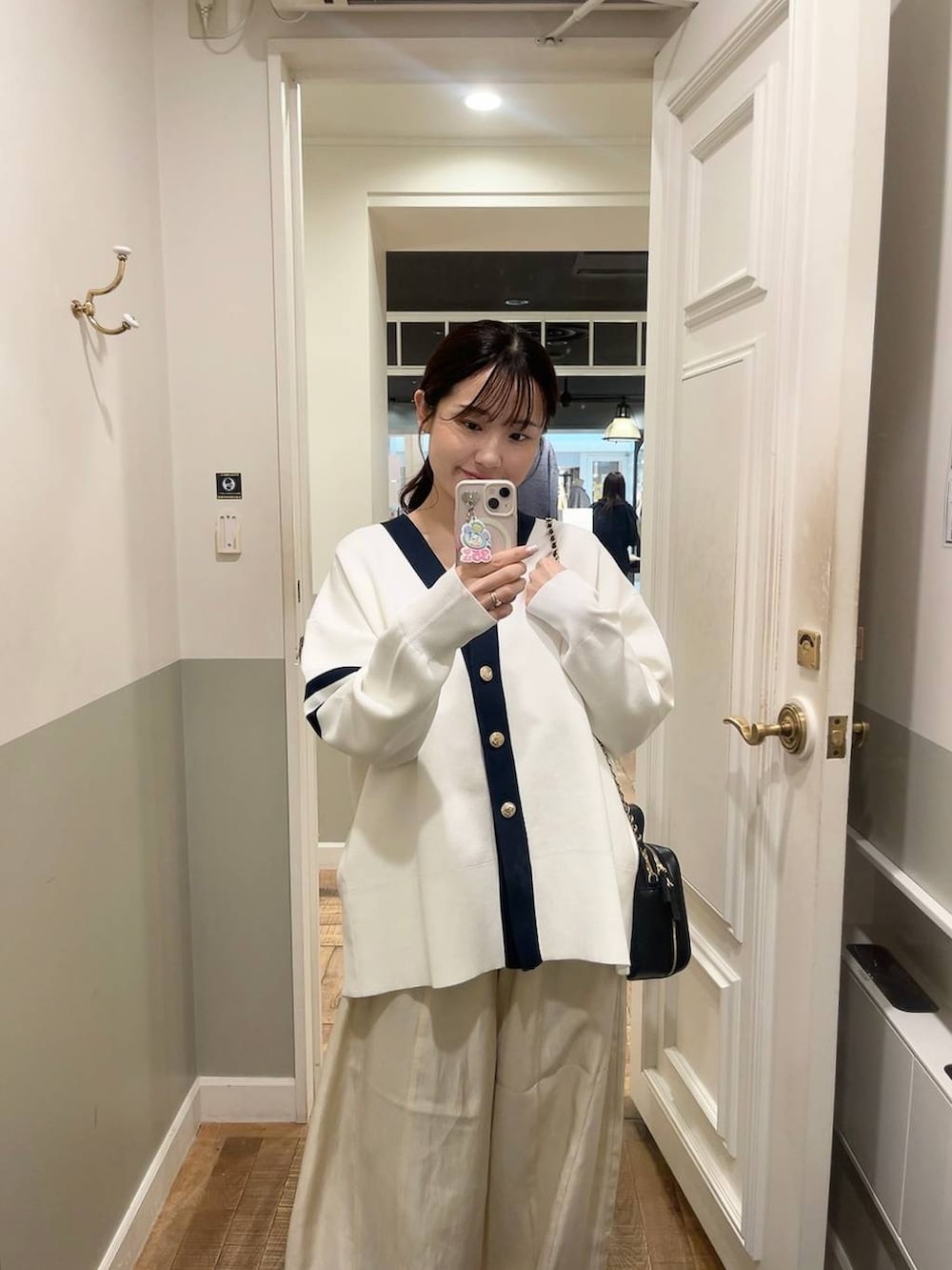 ブラック系のカーディガン/ボレロ、ホワイト系のその他パンツ、ブラック系のパンプスを着用したレディースの春コーディネートの2枚目の写真