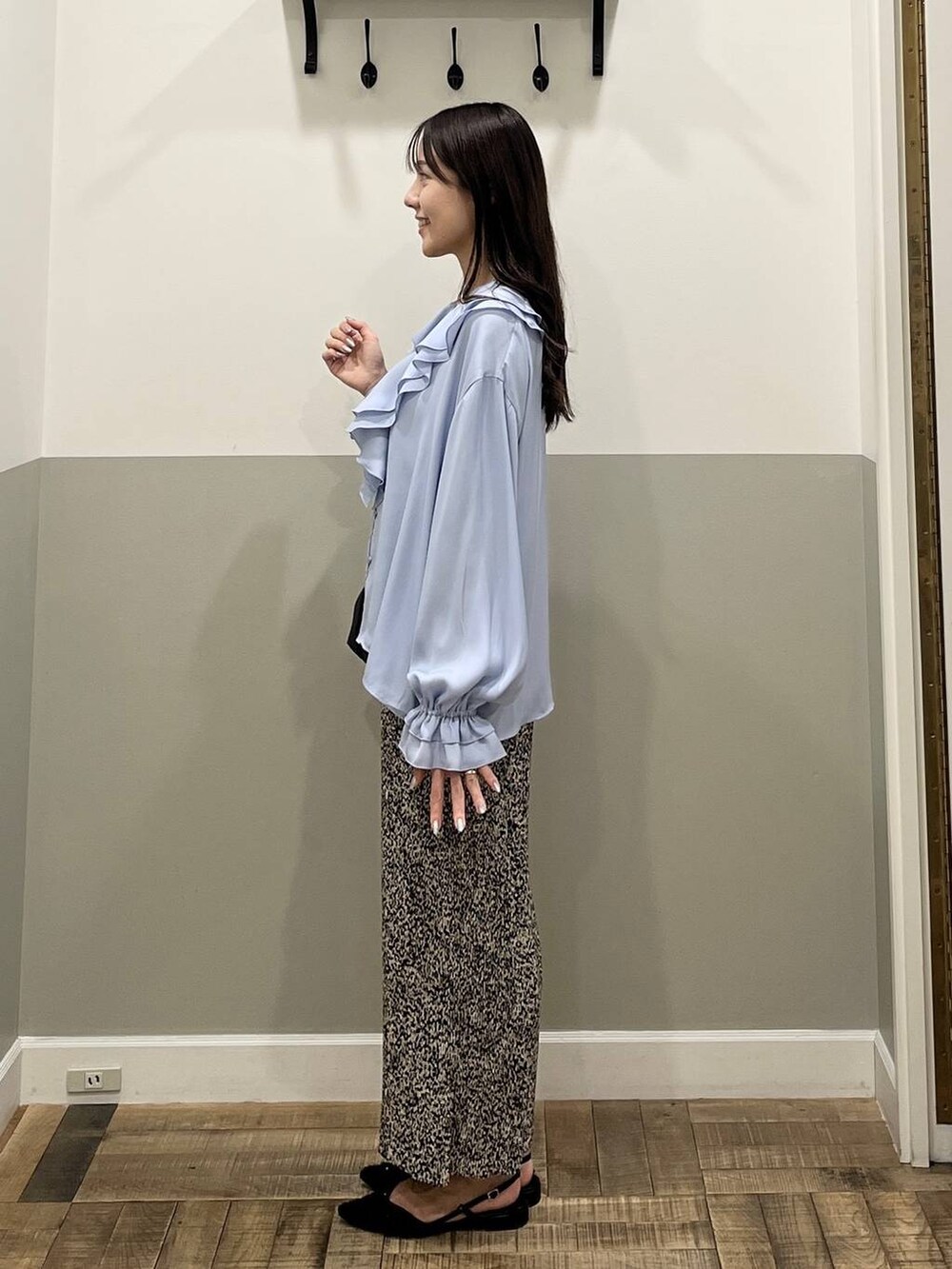 ベージュ系のスカート、ブラック系のショルダーバッグ、ホワイト系のキャミソールを着用したレディースの冬コーディネートの6枚目の写真