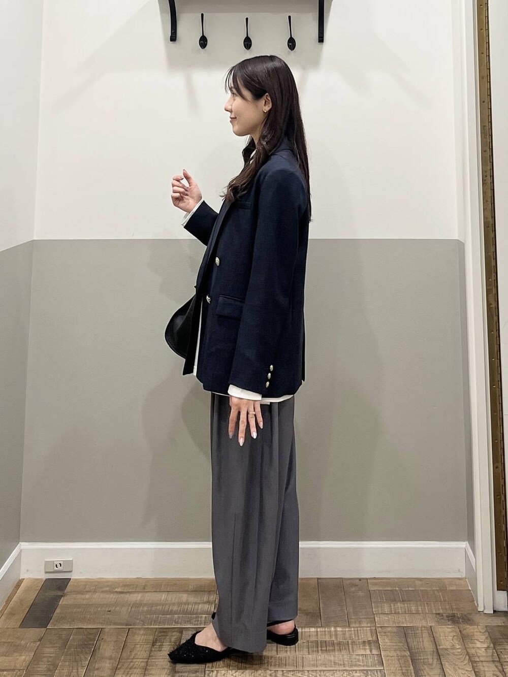 グレー系のスラックス、ブルー系のテーラードジャケット、ホワイト系のTシャツ/カットソーを着用したレディースの冬コーディネートの6枚目の写真