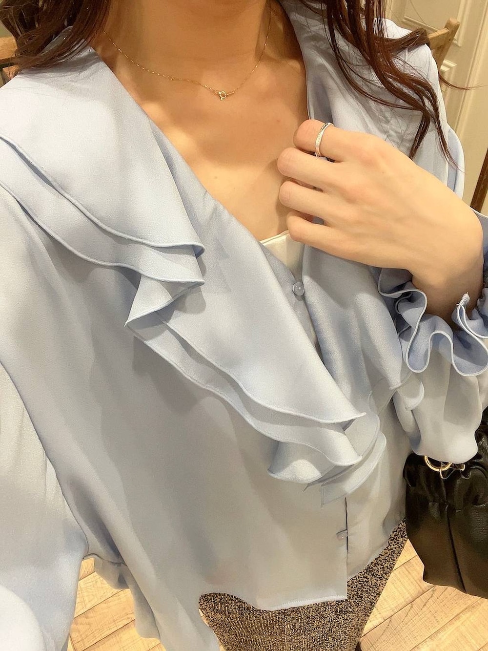 ベージュ系のスカート、ブラック系のショルダーバッグ、ホワイト系のキャミソールを着用したレディースの冬コーディネートの5枚目の写真