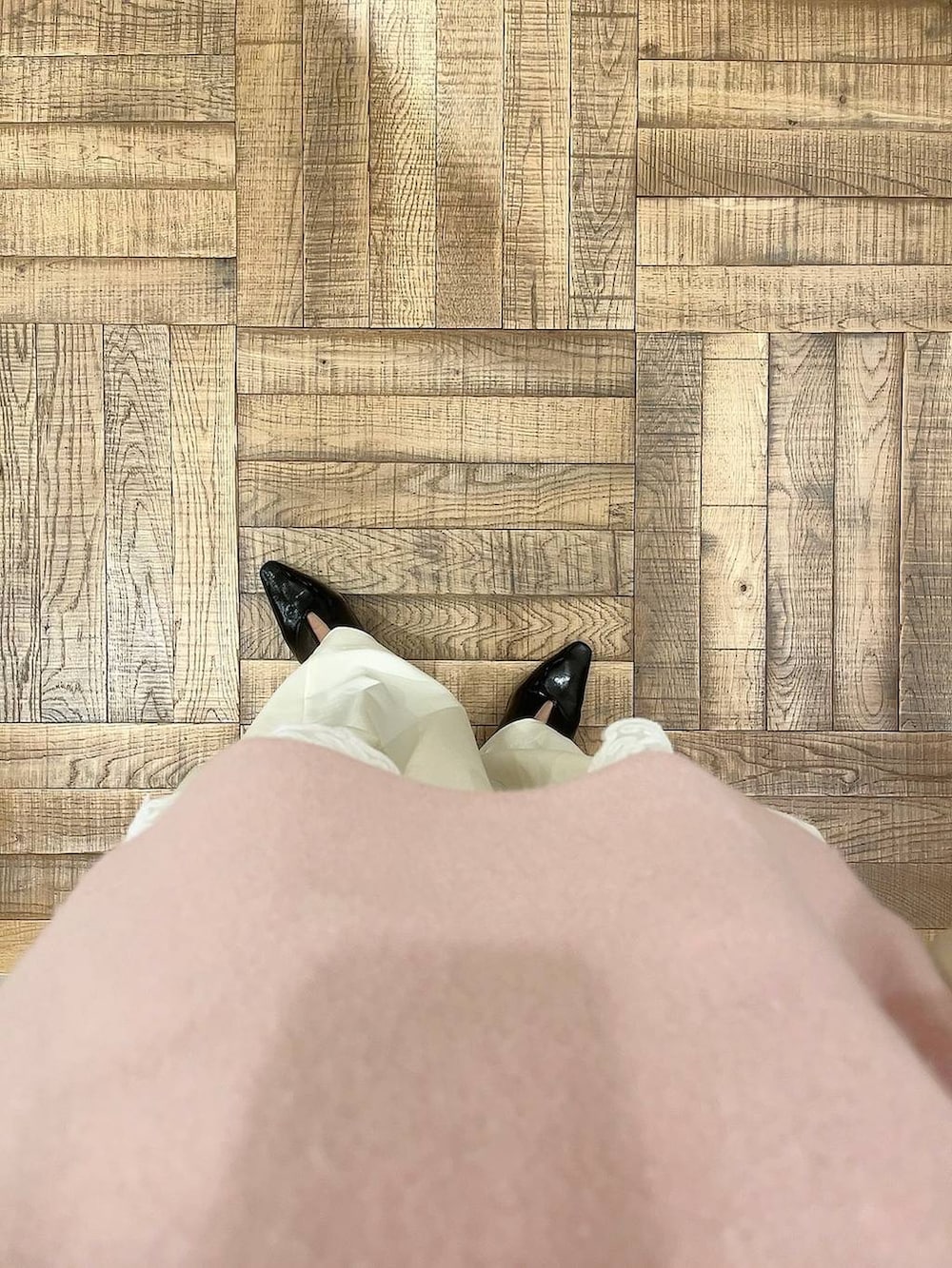 ピンク系のニット/セーター、ホワイト系のスラックス、ホワイト系のキャミソールを着用したレディースの冬コーディネートの3枚目の写真