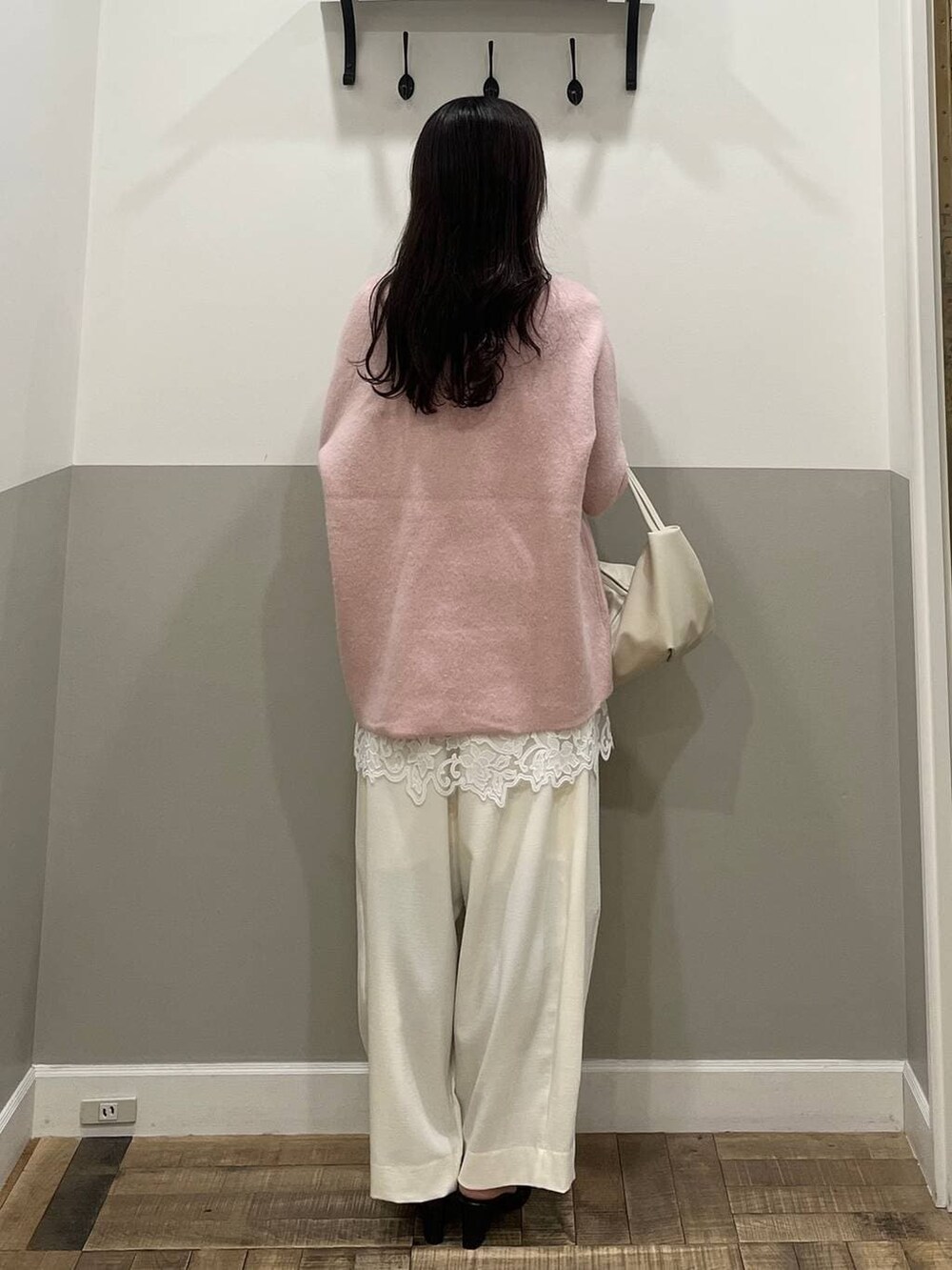 ピンク系のニット/セーター、ホワイト系のスラックス、ホワイト系のキャミソールを着用したレディースの冬コーディネートの5枚目の写真