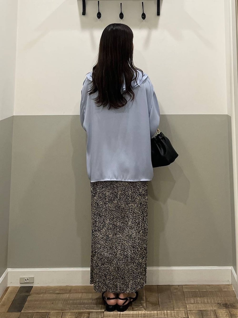 ベージュ系のスカート、ブラック系のショルダーバッグ、ホワイト系のキャミソールを着用したレディースの冬コーディネートの7枚目の写真