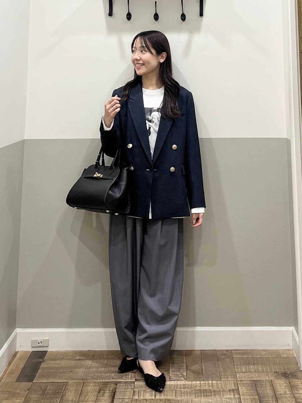 グレー系のスラックス、ブルー系のテーラードジャケット、ホワイト系のTシャツ/カットソーを着用したレディースの冬コーディネートの3枚目の写真