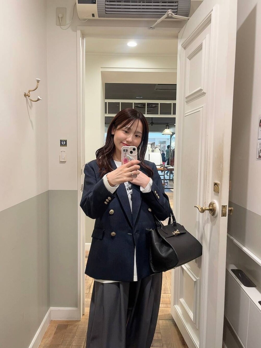 グレー系のスラックス、ブルー系のテーラードジャケット、ホワイト系のTシャツ/カットソーを着用したレディースの冬コーディネートの4枚目の写真