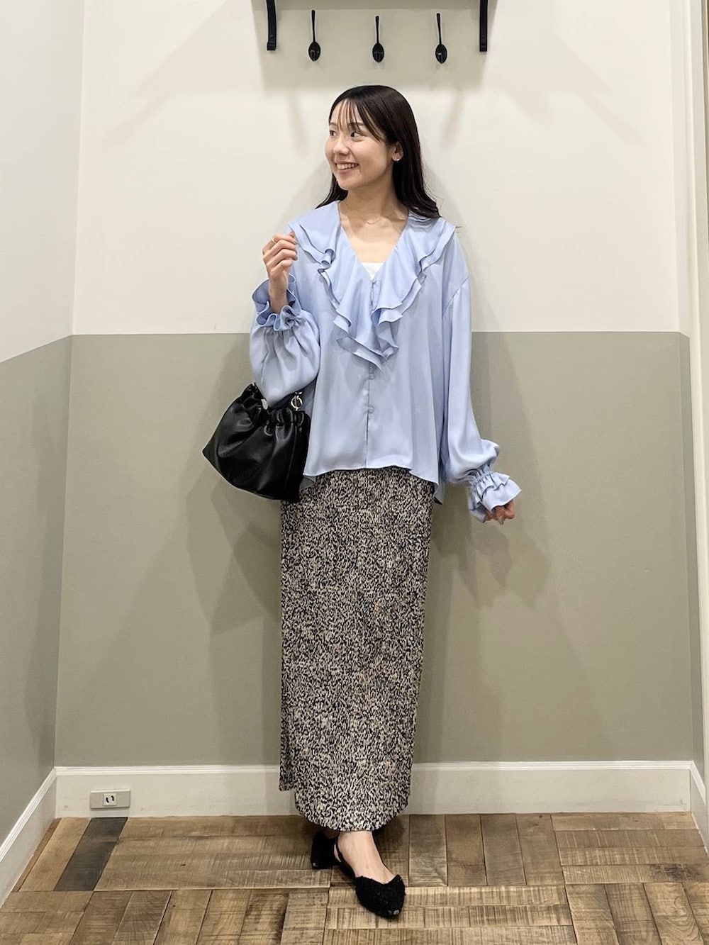 ベージュ系のスカート、ブラック系のショルダーバッグ、ホワイト系のキャミソールを着用したレディースの冬コーディネートの3枚目の写真