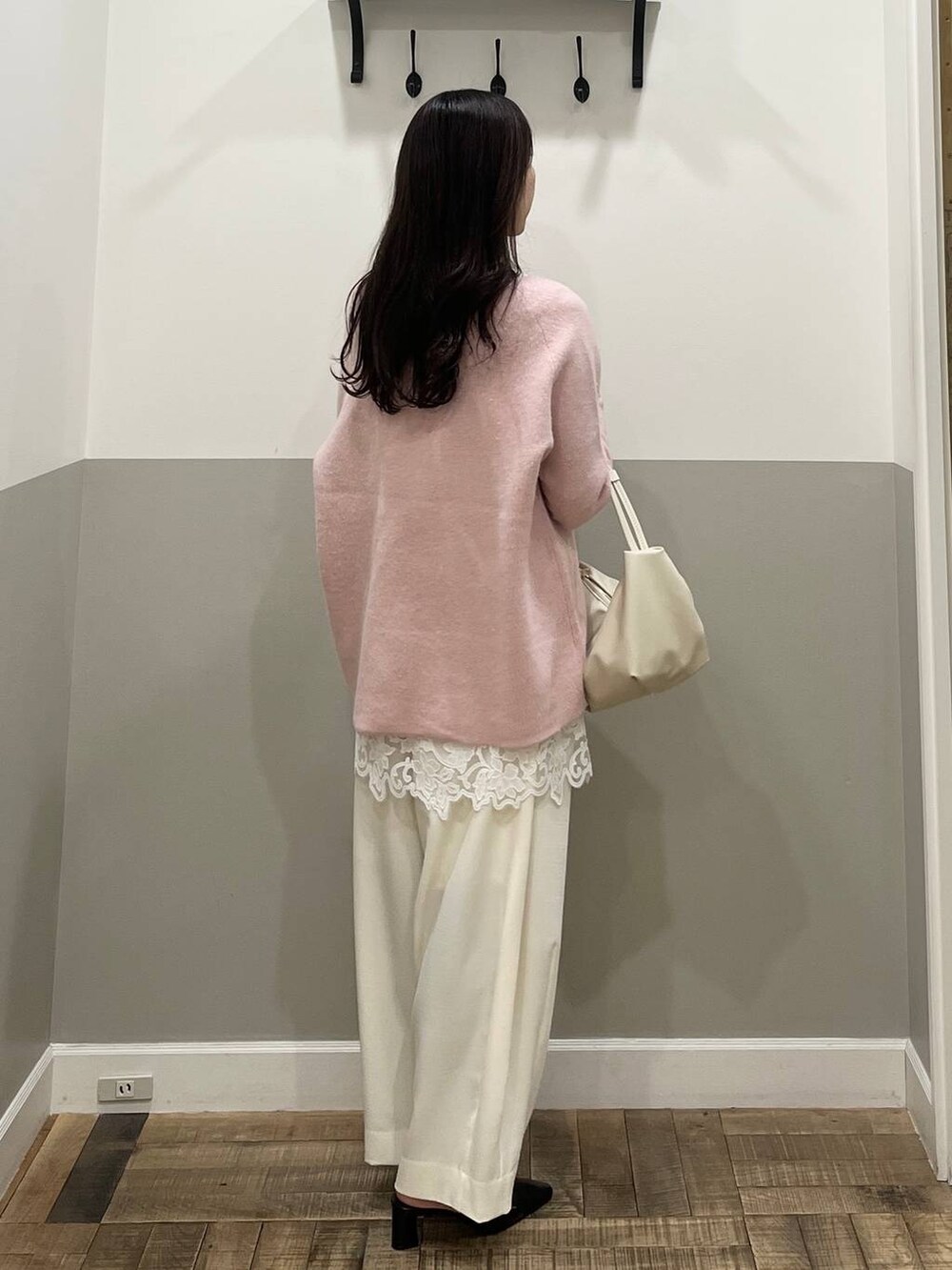 ピンク系のニット/セーター、ホワイト系のスラックス、ホワイト系のキャミソールを着用したレディースの冬コーディネートの6枚目の写真