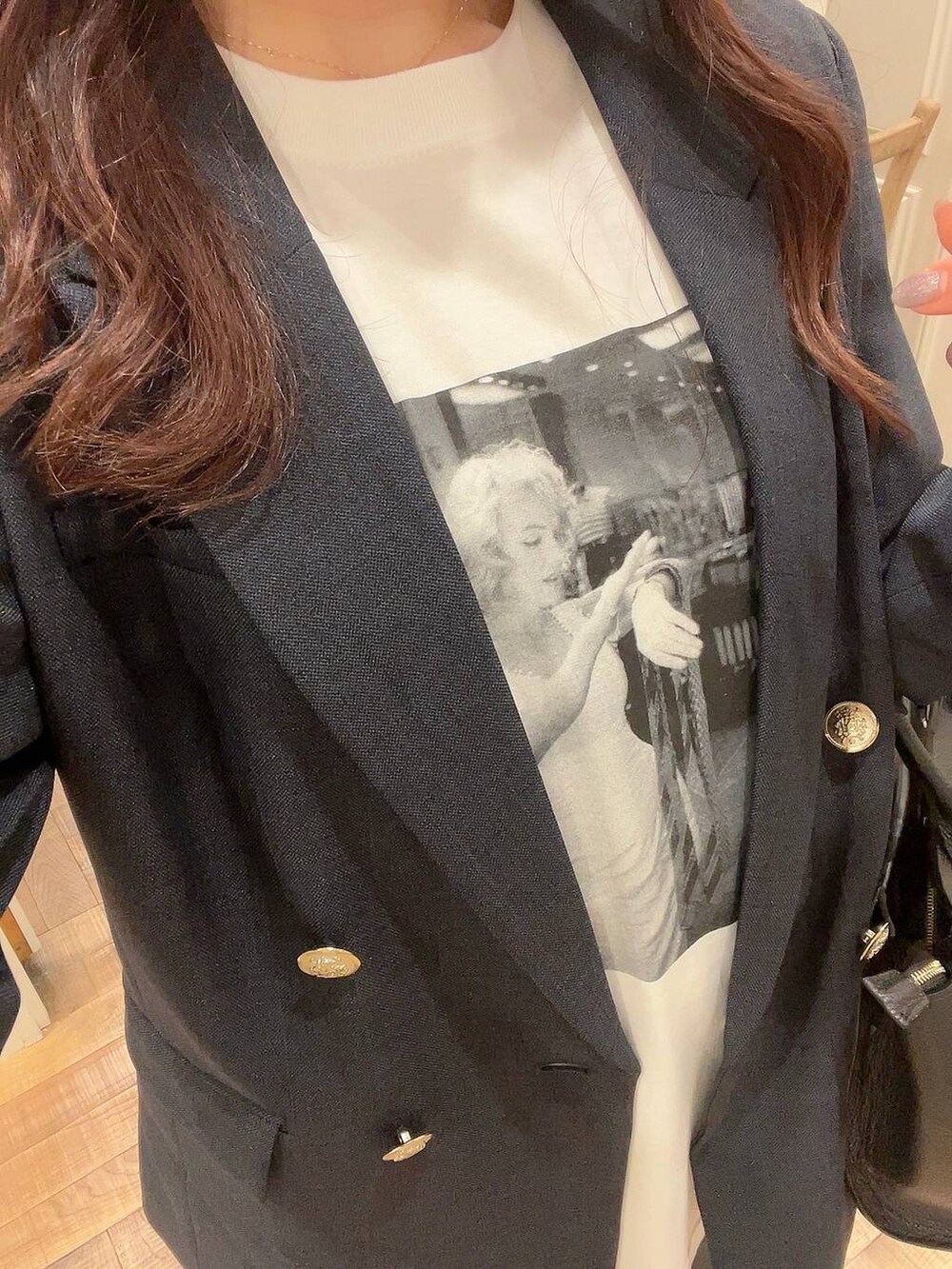 グレー系のスラックス、ブルー系のテーラードジャケット、ホワイト系のTシャツ/カットソーを着用したレディースの冬コーディネートの5枚目の写真