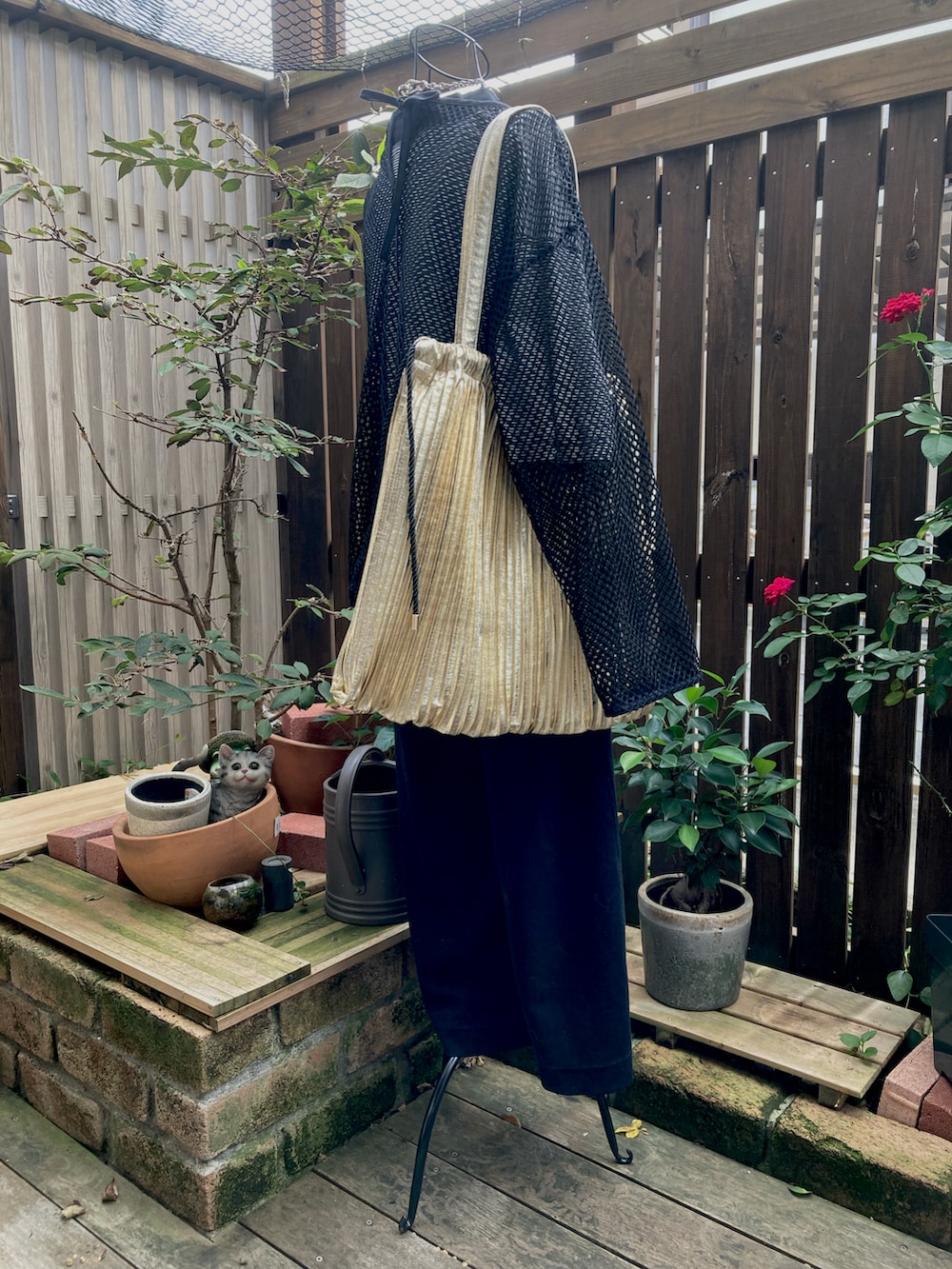 ブラック系のスニーカー、ブラック系のその他パンツ、ブラック系のTシャツ/カットソーを着用したレディースの秋コーディネートの2枚目の写真