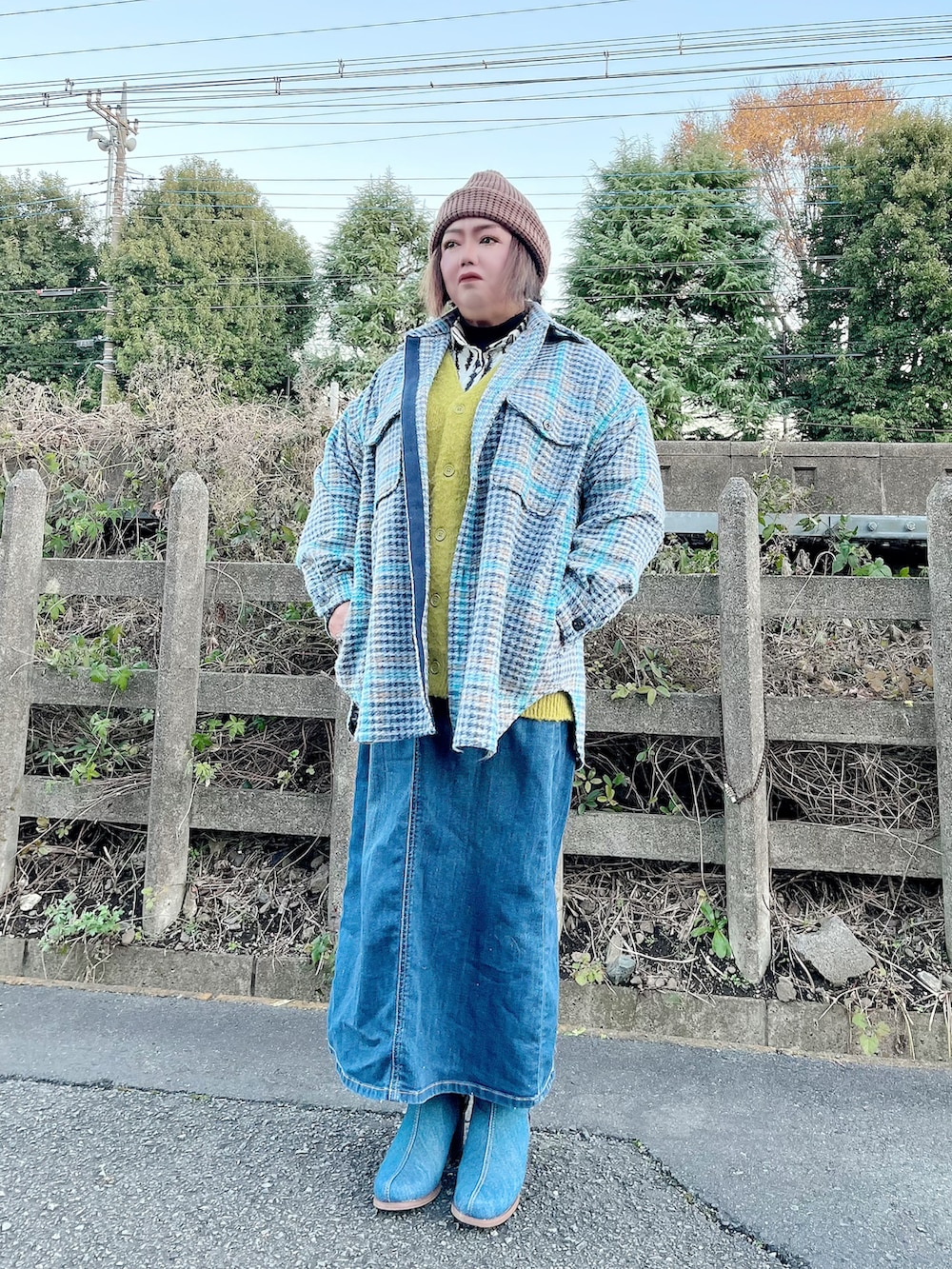 グリーン系のカーディガン/ボレロ、ブルー系のデニムスカート、その他のブーツを着用したレディースの冬コーディネートの2枚目の写真