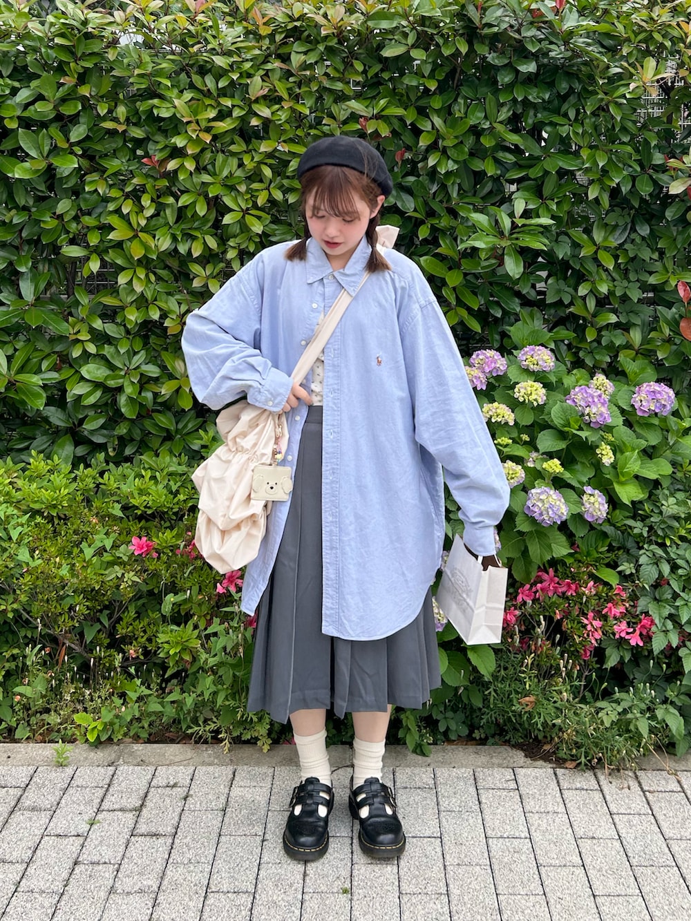 ブルー系のキャミソール、グレー系のスカート、ホワイト系のショルダーバッグを着用したレディースの夏コーディネートの2枚目の写真