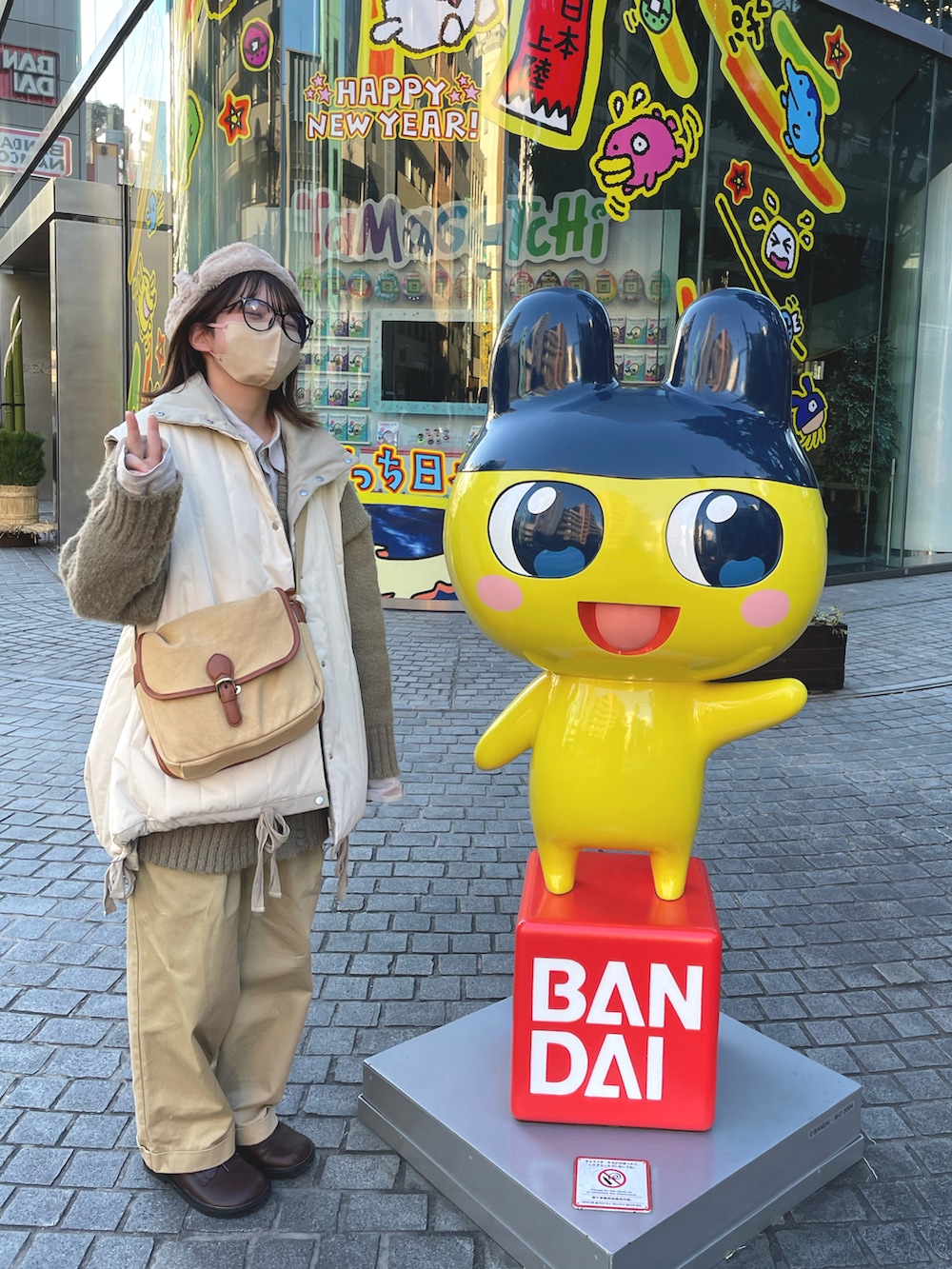 ベージュ系のショルダーバッグ、ホワイト系のダウンジャケット/コート、ベージュ系のチノパンツを着用したレディースの冬コーディネートの2枚目の写真